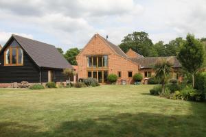 a large brick house with a grass yard at Superb Stokesby Barn Apartment - Norfolk Broads & Norwich in Stokesby