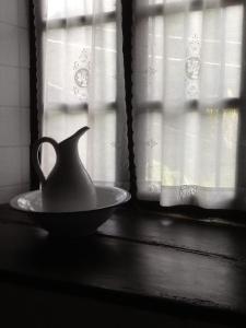 a pitcher on a plate on a window sill at Casa Do Concello in Arnado +40 photos