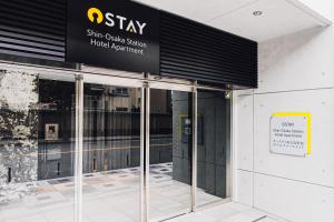 een toegang tot een gebouw met een bord erop bij Ostay Shin-Osaka Hotel Apartment in Osaka
