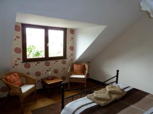 1 dormitorio con 1 cama, 2 sillas y ventana en Chaillac Bed & Breakfast, en Chaillac