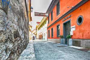 an alley in an old town with orange buildings at Cukrarna Guest Accommodation in Kranj