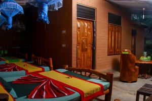 a room with three beds in front of a building at YalaWay Nature Villa in Tissamaharama
