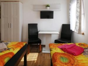 sypialnia z 2 łóżkami i 2 krzesłami oraz biurkiem w obiekcie Apartmány Aranka w mieście Žatec