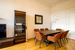 a dining room with a table and chairs and a television at **Traumhafte City-Wohnung // 120qm // 4-Räume** in Leipzig