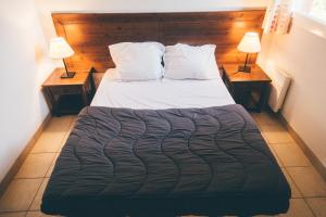 uma cama num quarto com duas mesas e duas lâmpadas em Terres de France - Domaine de Claire Rive em Prayssac