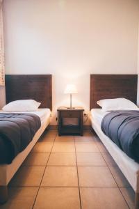 PrayssacにあるTerres de France - Domaine de Claire Riveのベッド2台、テーブル(ランプ付)が備わる客室です。