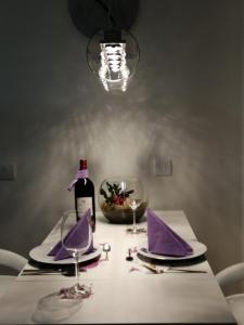 Nova Pazova的住宿－Apartman Lux，一张带紫色餐巾的桌子和一瓶葡萄酒