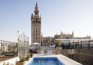 uma vista para um edifício com uma grande torre de relógio em EME Catedral Hotel em Sevilha