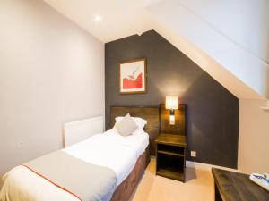 a bedroom with two beds and a black wall at OYO Hotel Majestic in Barrow in Furness