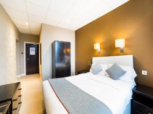 バロー・イン・ファーネスにあるOYO Hotel Majesticのベッドルーム(青い枕の大きな白いベッド付)