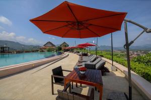 eine Terrasse mit einem Tisch, Stühlen und einem Sonnenschirm in der Unterkunft Luangprabang View Hotel in Luang Prabang