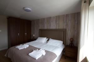 Corbiere Phare Apartments في سات بريلاد: غرفة نوم عليها سرير وفوط