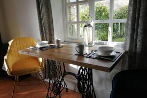 a wooden table with two bowls on it next to a window at Stunning cosy barn in peaceful rural Cornwall in Truro +25 photos