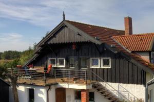 a black house with a porch and a balcony at Morgensonne in Hiddensee