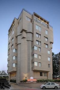 a tall building with a car parked in front of it at Effotel by Sayaji Vadodara in Vadodara