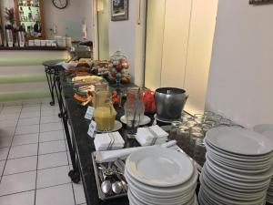 a table with a bunch of plates on it at Ipê Guaru Hotel in Guarulhos