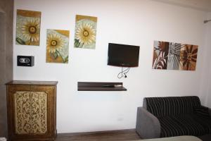 a living room with a couch and a tv on a wall at B&B Il Profumo del Porto in Trapani