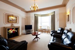 a living room with leather furniture and a fireplace at Burbage Holiday Lodge Apartment 2 in Blackpool