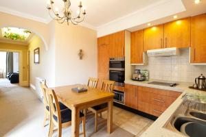 a kitchen with a wooden table and a dining room at Burbage Holiday Lodge Apartment 2 in Blackpool
