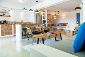 cocina y sala de estar con mesa y sillas en Galini Villas, en Mikros Gialos