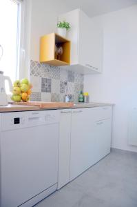 a kitchen with white cabinets and a bowl of fruit at Razgled/The View in Koper