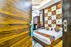 a bedroom with a bed and a wooden wall at FabHotel Aman Residency Sharifpura in Amritsar