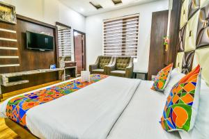 a bedroom with a large bed and a tv at FabHotel Aman Residency Sharifpura in Amritsar