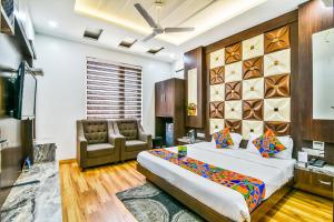 a bedroom with a bed and a couch and a chair at FabHotel Aman Residency Sharifpura in Amritsar