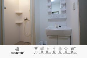 La petite salle de bains est pourvue d'un lavabo et d'une douche. dans l'établissement Westay Designers House/6 mins to Shinsaibashi206, à Osaka