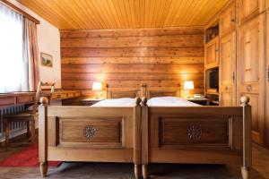 a bedroom with a bed in a room with wooden walls at Swiss Chalet-Style Hotel Walliser Spycher in Riederalp
