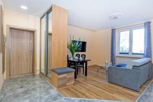 a living room with a couch and a table at Apartament Amber z garażem moj-sopot pl in Sopot