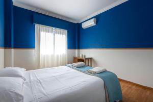 アテネにあるBlue & Red Apartmentの青い壁のベッドルーム1室、ベッド1台(タオル2枚付)