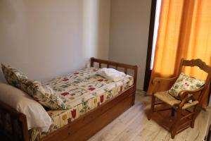 a small bedroom with a bed and a chair at Casa Rural Tarayuela in Cantavieja