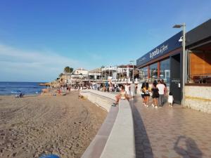 un groupe de personnes marchant sur la plage dans l'établissement Apartamento Playa Jávea, à Jávea
