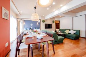 a dining room and living room with a table and chairs at Hotel Haabesu Okinawa in Urazoe