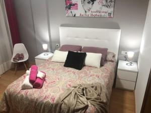 Un dormitorio con una cama grande con dos mesitas de noche. en Apartamento céntrico en León, en León