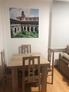 a dining room table with chairs and a painting on the wall at Apartamento céntrico en León in León