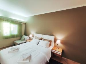 a bedroom with a large white bed and a chair at Philoxenia in Kalabaka +70 photos