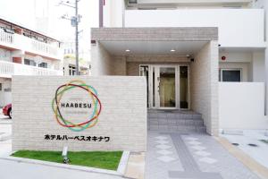 a building with a sign in front of it at Hotel Haabesu Okinawa in Urasoe