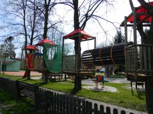 einen Spielplatz mit Rutsche in einem Park in der Unterkunft Ośrodek Wczasowo - Kolonijny Słoneczko in Łeba