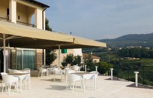 d'une terrasse avec des tables, des chaises et un parasol. dans l'établissement Villa Allegri Agriturismo di Charme, à Negrar