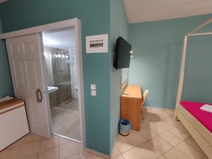 a bathroom with a shower and a door leading to a bedroom at Philoxenia in Kalabaka