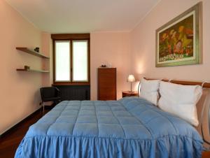 a bedroom with a blue bed and a window at Villa Onorina in Carimate