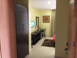 een hotelkamer met een bureau en een slaapkamer bij AMOR Hotel Ekiti in Ado Ekiti
