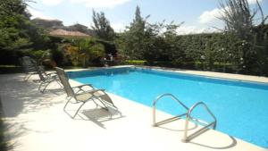 a swimming pool with two lawn chairs next to it at Garr Hotel in Kigali