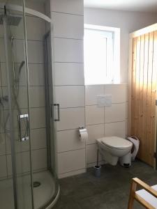 a bathroom with a shower and a toilet at Ferienhaus - Heimathafen Tossens in Butjadingen +17 photos