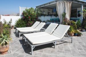 three white lounge chairs on a patio with plants at Résidence papillon bleu in Tamraght Ouzdar