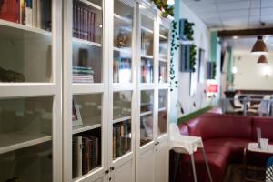 een bibliotheek met een rode bank en boeken op planken bij Hostal Aznaitin in Baeza