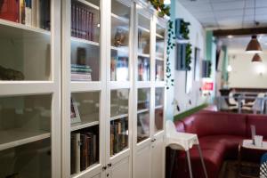 biblioteca con sofá rojo y libros en estanterías en Hostal Aznaitin, en Baeza