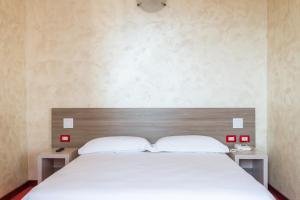 - une chambre avec un grand lit blanc et 2 tables de chevet dans l'établissement Hotel italia dormelletto, à Dormelletto